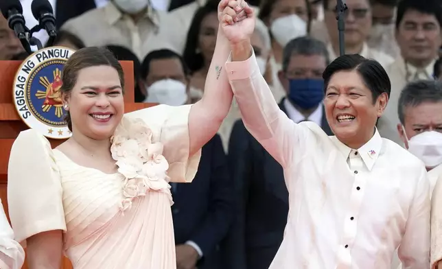FILE - Philippine President Ferdinand Marcos Jr., center right, and Vice President Sara Duterte, daughter of former Philippine President Rodrigo Duterte, raise hands during the inauguration ceremony at National Museum on Thursday, June 30, 2022 in Manila, Philippines. (AP Photo/Aaron Favila, File)