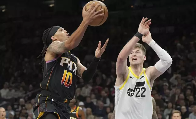 Phoenix Suns guard Damion Lee (10) drives against Utah Jazz forward Kyle Filipowski (22) during the first half of an NBA basketball game, Friday, Feb. 7, 2025, in Phoenix. (AP Photo/Rick Scuteri)