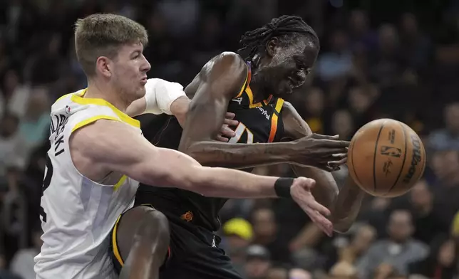 Utah Jazz forward Kyle Filipowski (22) fouls Phoenix Suns center Bol Bol during the first half of an NBA basketball game, Friday, Feb. 7, 2025, in Phoenix. (AP Photo/Rick Scuteri)