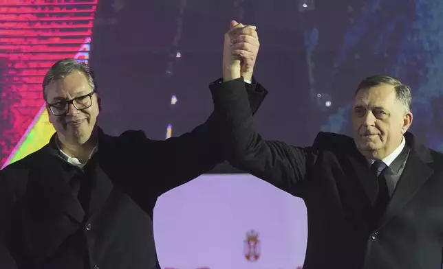 Serbian President Aleksandar Vucic, left, poses with Bosnian Serb political leader Milorad Dodik during a rally marking the country's Statehood Day in Sremska Mitrovica, Serbia, Saturday, Feb. 15, 2025. (AP Photo/Antonio Ahel)