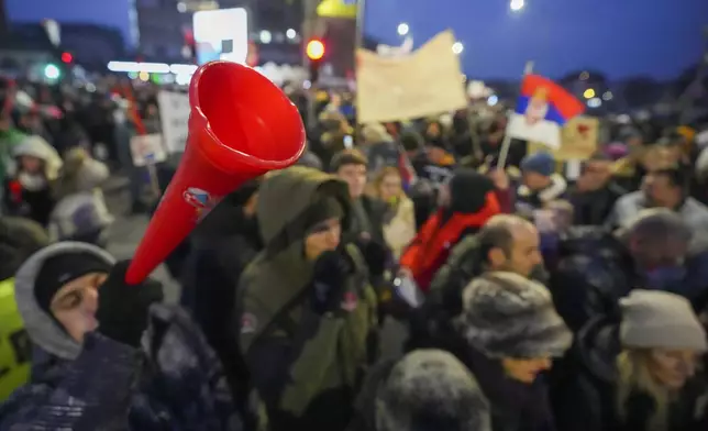 A man blows a vuvuzela during a student-led large protest and a 15-hour blockade of the streets in Serbian industrial town of Kragujevac, to protest the deaths of 15 people killed in the November collapse of a train station canopy, Saturday, Feb. 15, 2025. (AP Photo/Darko Vojinovic)