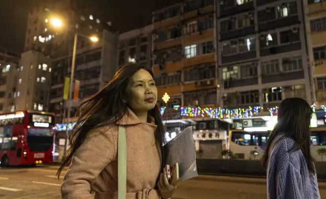 Sze Lai-shan, the deputy director of the Society for Community Organization, walks on her way to visit residents in the subdivided flat in Sham Shui Po district of Hong Kong, on Feb. 6, 2025. (AP Photo/Chan Long Hei)