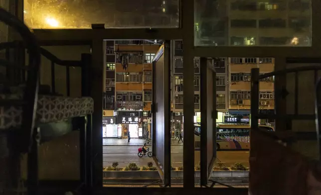 Residential buildings are seen through a window of a bed space in Sham Shui Po district of Hong Kong, on Feb. 6, 2025. (AP Photo/Chan Long Hei)