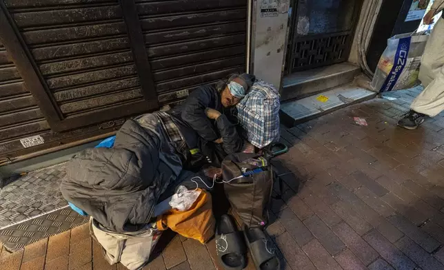 A homeless person sleeps on a street in Sham Shui Po district of Hong Kong, on Feb. 6, 2025. (AP Photo/Chan Long Hei)