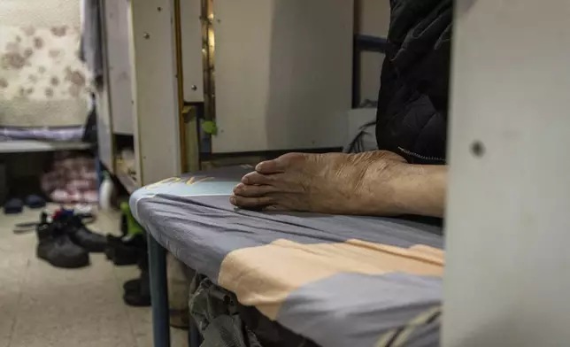 A resident rests in his bed space in Sham Shui Po district of Hong Kong, on Feb. 6, 2025. (AP Photo/Chan Long Hei)