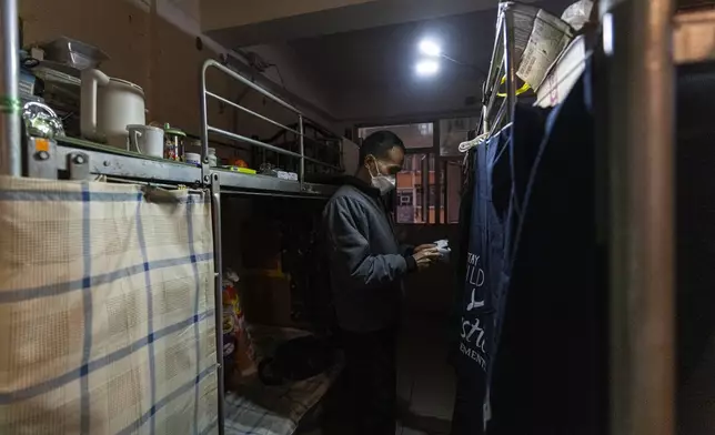 Resident Chung Shing-sun stands near his bed space in Sham Shui Po district of Hong Kong, on Feb. 6, 2025. (AP Photo/Chan Long Hei)