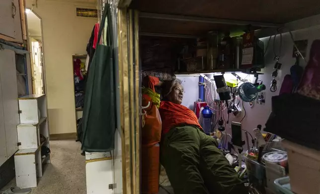 A resident rests in his bed space in Sham Shui Po district of Hong Kong, on Feb. 6, 2025. (AP Photo/Chan Long Hei)