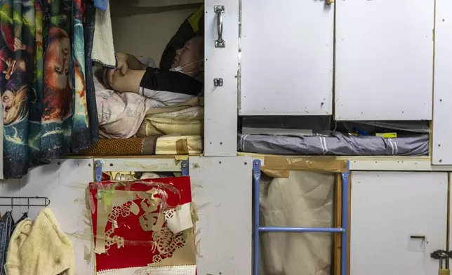 A resident rests in his bed space in Sham Shui Po district of Hong Kong, on Feb. 6, 2025. (AP Photo/Chan Long Hei)