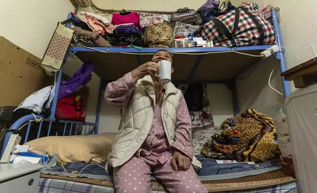 Resident Tsang Mei Qin sits at her subdivided flat in Sham Shui Po district of Hong Kong, on Feb. 6, 2025. (AP Photo/Chan Long Hei)