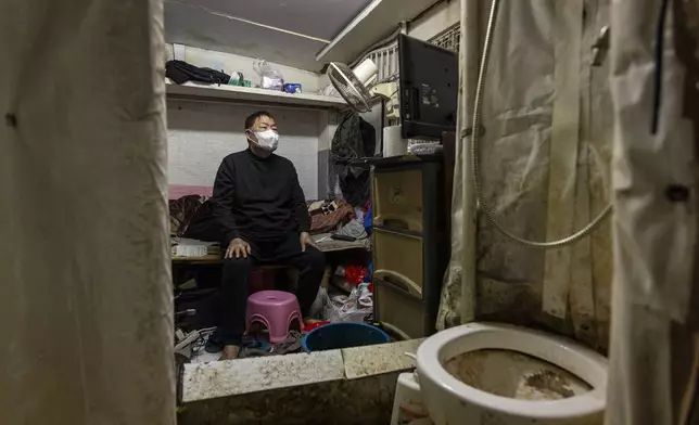 A resident who gave his name as Chiu watches television at his subdivided flat in Sham Shui Po district of Hong Kong, on Feb. 6, 2025. (AP Photo/Chan Long Hei)