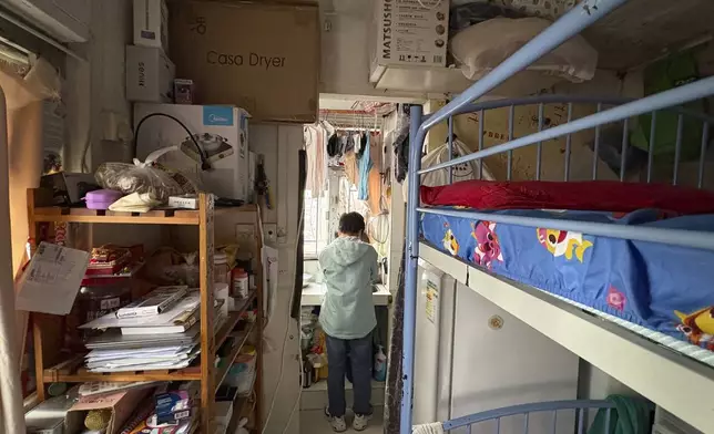 Housewife Jimmy Au stands in her kitchen at home in a residential area of Prince Edward district in Hong Kong on Jan. 21, 2025. (AP Photo/Kanis Leung)