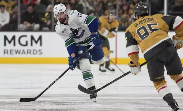 Vancouver Canucks defenseman Filip Hronek (17) passes past Vegas Golden Knights right wing Victor Olofsson (95) during the first period of an NHL hockey game Saturday, Feb. 22, 2025, in Las Vegas. (AP Photo/John Locher)