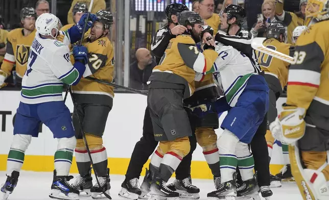 Vegas Golden Knights and Vancouver Canucks players scuffle during the third period of an NHL hockey game Saturday, Feb. 22, 2025, in Las Vegas. (AP Photo/John Locher)