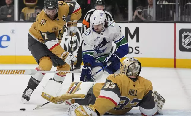 Vancouver Canucks right wing Conor Garland (8) attempts a shot on Vegas Golden Knights goaltender Adin Hill (33) during the third period of an NHL hockey game Saturday, Feb. 22, 2025, in Las Vegas. (AP Photo/John Locher)