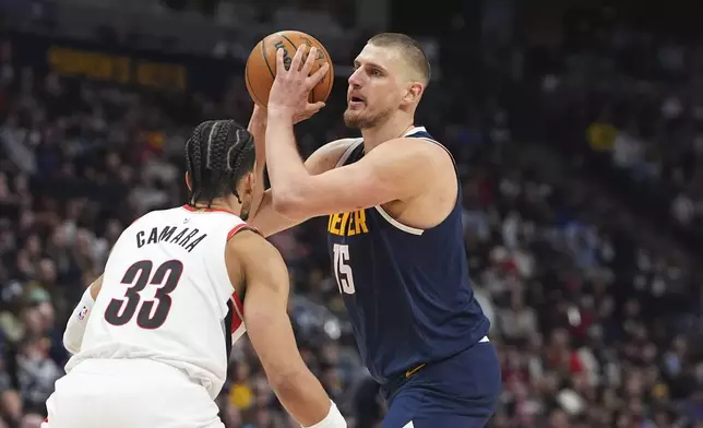 Denver Nuggets center Nikola Jokic, right, drives to the basket as Portland Trail Blazers forward Toumani Camara defends in the first half of an NBA basketball game Wednesday, Feb. 12, 2025, in Denver. (AP Photo/David Zalubowski)