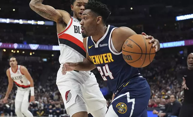 Denver Nuggets guard Jalen Pickett (24) drives to the basket as Portland Trail Blazers guard Anfernee Simons defends in the first half of an NBA basketball game Wednesday, Feb. 12, 2025, in Denver. (AP Photo/David Zalubowski)