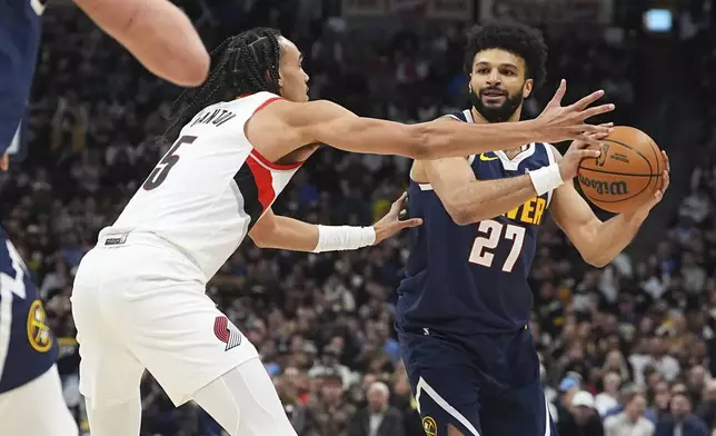Denver Nuggets guard Jamal Murray, right, looks to pass the ball as Portland Trail Blazers guard Dalano Banton defends in the first half of an NBA basketball game Wednesday, Feb. 12, 2025, in Denver. (AP Photo/David Zalubowski)