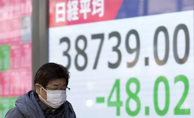 A person walks in front of an electronic stock board showing Japan's Nikkei index at a securities firm Monday, Feb. 10, 2025, in Tokyo. (AP Photo/Eugene Hoshiko)
