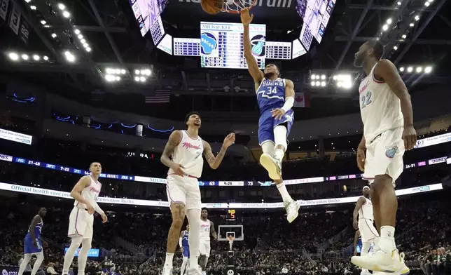 Milwaukee Bucks' Giannis Antetokounmpo dunks between Miami Heat's Kel'el Ware and Andrew Wiggins during the second half of an NBA basketball game Sunday, Feb. 23, 2025, in Milwaukee. (AP Photo/Morry Gash)