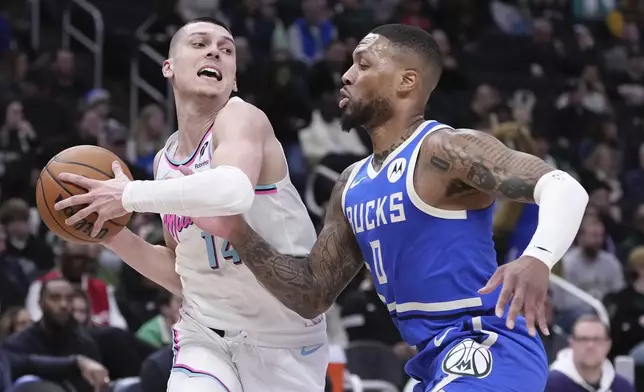 Miami Heat's Tyler Herro tries to get past Milwaukee Bucks' Damian Lillard during the first half of an NBA basketball game Sunday, Feb. 23, 2025, in Milwaukee. (AP Photo/Morry Gash)