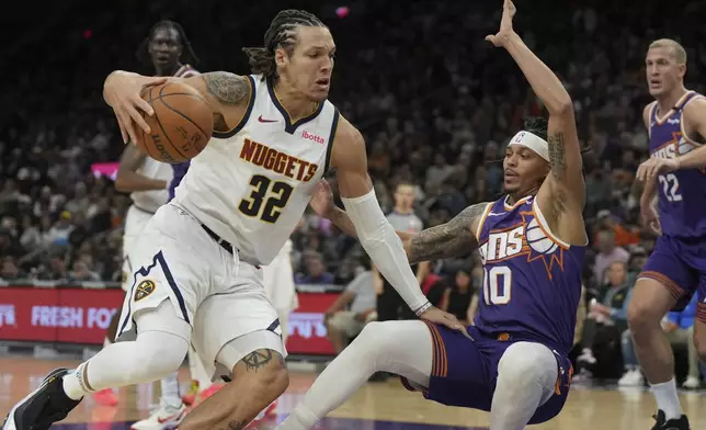 Denver Nuggets forward Aaron Gordon (32) draws a blocking foul on Phoenix Suns guard Damion Lee (10) during the first half of an NBA basketball game, Saturday, Feb. 8, 2025, in Phoenix. (AP Photo/Rick Scuteri)