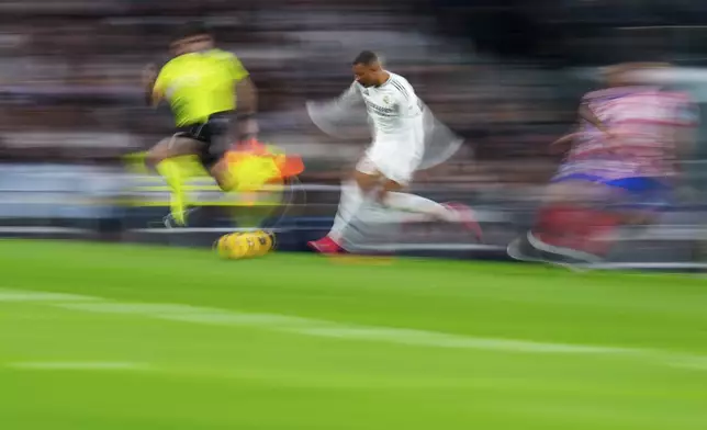 Real Madrid's Kylian Mbappe, center, runs with the ball during a Spanish La Liga soccer match between Real Madrid and Atletico Madrid at the Santiago Bernabeu stadium in Madrid, Saturday, Feb. 8, 2025. (AP Photo/Manu Fernandez)
