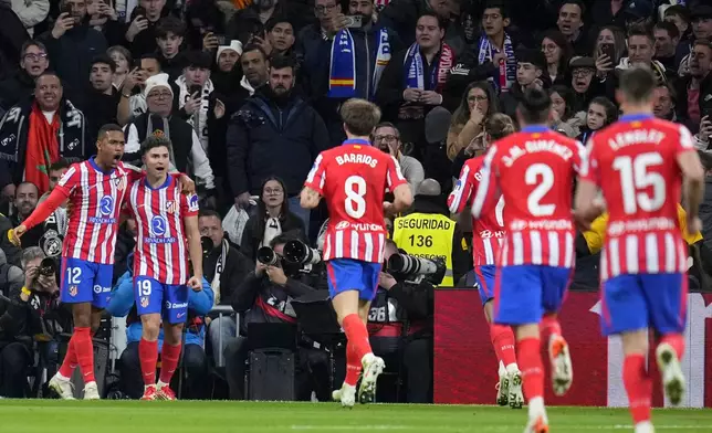 Atletico Madrid's Julian Alvarez, 2nd left, celebrates after scoring the opening goal from the penalty spot during a Spanish La Liga soccer match between Real Madrid and Atletico Madrid at the Santiago Bernabeu stadium in Madrid, Saturday, Feb. 8, 2025. (AP Photo/Manu Fernandez)