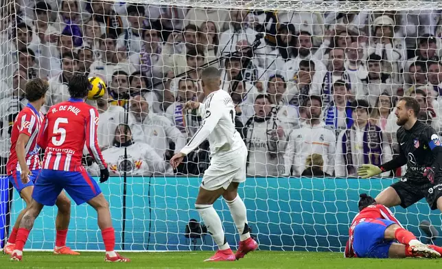 Real Madrid's Kylian Mbappe, center, scores his side's first goal during a Spanish La Liga soccer match between Real Madrid and Atletico Madrid at the Santiago Bernabeu stadium in Madrid, Saturday, Feb. 8, 2025. (AP Photo/Manu Fernandez)