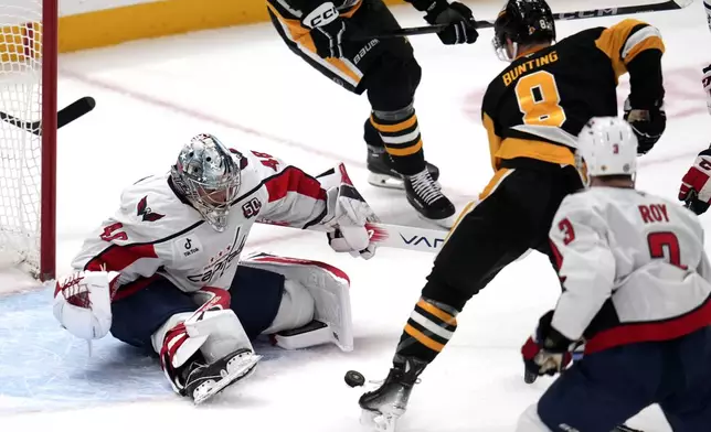 Washington Capitals goaltender Logan Thompson (48) stops a shot by Pittsburgh Penguins' Michael Bunting (8) during the first period of an NHL hockey game in Pittsburgh, Saturday, Feb. 22, 2025. (AP Photo/Gene J. Puskar)