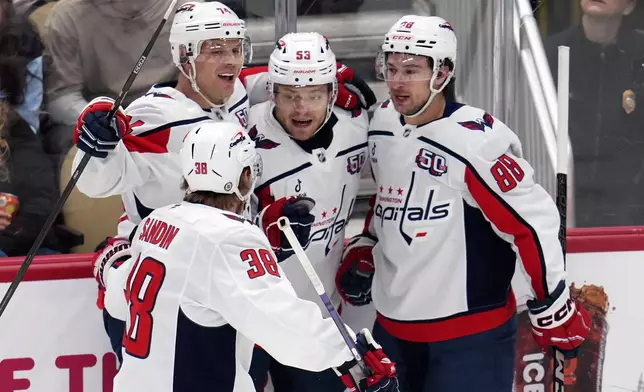 Washington Capitals' Ethen Frank (53) celebrates with teammates after scoring a goal during the first period of an NHL hockey game against the Pittsburgh Penguins in Pittsburgh, Saturday, Feb. 22, 2025. (AP Photo/Gene J. Puskar)