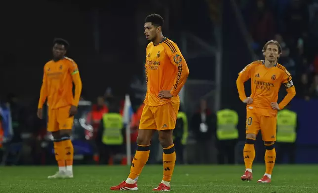 Real Madrid's Jude Bellingham, centre and Luka Modric, right, react after Espanyol's Carlos Romero scored the opening goal during a Spanish La Liga soccer match between Espanyol and Real Madrid at the Lluis Companys Olympic Stadium in Barcelona, Spain, Saturday Feb.1, 2025. (AP Photo/Joan Monfort)