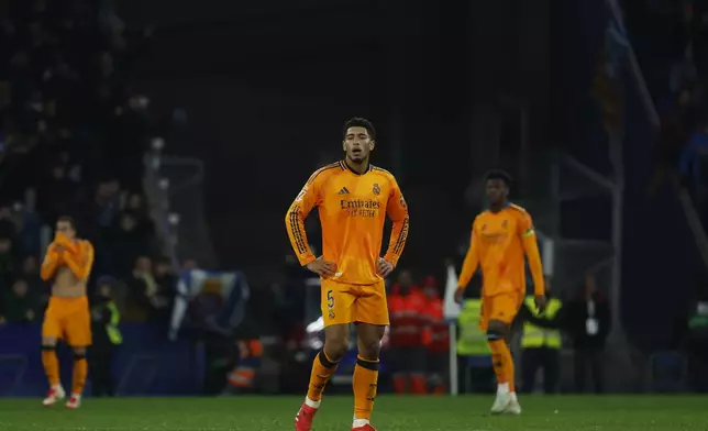 Real Madrid's Jude Bellingham, centre, reacts after Espanyol's Carlos Romero scored the opening goal during a Spanish La Liga soccer match between Espanyol and Real Madrid at the Lluis Companys Olympic Stadium in Barcelona, Spain, Saturday Feb.1, 2025. (AP Photo/Joan Monfort)