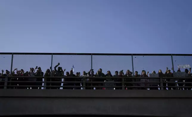 Demonstrators gather on an overpass over the 110 freeway during a protest calling for immigration reform Sunday, Feb. 2, 2025, in Los Angeles. (AP Photo/Eric Thayer)