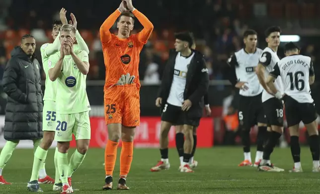 Barcelona's goalkeeper Wojciech Szczęsny and Dani Olmo applaud to their supporters at the end of a Spanish Copa del Rey, or King's Cup, quarter-final soccer match between Valencia and Barcelona at the Mestalla Stadium in Valencia, Spain, Thursday Feb. 6, 2025. (AP Photo/Alberto Saiz)