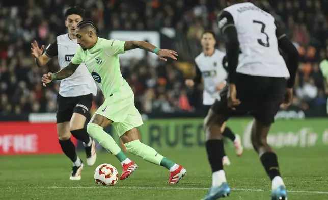 Barcelona's Raphinha fights for the ball during a Spanish Copa del Rey, or King's Cup, quarter-final soccer match between Valencia and Barcelona at the Mestalla Stadium in Valencia, Spain, Thursday Feb. 6, 2025. (AP Photo/Alberto Saiz)