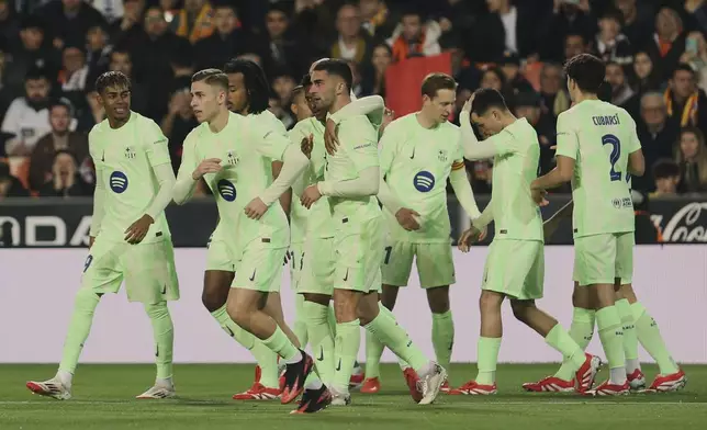 Barcelona's Ferran Torres celebrates with team mates the opening goal during a Spanish Copa del Rey, or King's Cup, quarter-final soccer match between Valencia and Barcelona at the Mestalla Stadium in Valencia, Spain, Thursday Feb. 6, 2025. (AP Photo/Alberto Saiz)