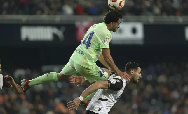 Barcelona's Pablo Torre fights for the ball against Valencia's Rafa Mir during a Spanish Copa del Rey, or King's Cup, quarter-final soccer match between Valencia and Barcelona at the Mestalla Stadium in Valencia, Spain, Thursday Feb. 6, 2025. (AP Photo/Alberto Saiz)