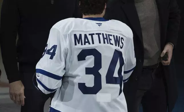 Vancouver Canucks owner Francesco Aquilini, left, looks on as Prince Harry, the Duke of Sussex, shakes hands with Toronto Maple Leafs' Auston Matthews (34) before an NHL hockey game against the Canucks in Vancouver, British Columbia, Saturday, Feb. 8, 2025. (Ethan Cairns/The Canadian Press via AP)