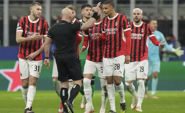 AC Milan's players argue with Referee Szymon Marciniak of Poland after he sent off AC Milan's Theo Hernandez, right, during Champions League, playoff second leg soccer match between AC Milan and Feyenoord, at the San Siro stadium in Milan, Italy, Tuesday, Feb.18, 2025. (AP Photo/Luca Bruno)