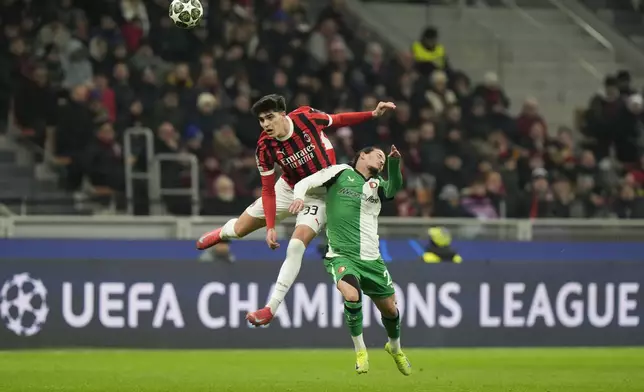 AC Milan's Davide Bartesaghi, left, jumps for a header with Feyenoord's Anis Hadj Moussa during Champions League, playoff second leg soccer match between AC Milan and Feyenoord, at the San Siro stadium in Milan, Italy, Tuesday, Feb.18, 2025. (AP Photo/Luca Bruno)