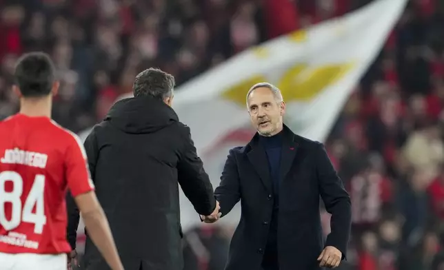 Monaco's head coach Adi Huetter, right, shakes hands with Benfica's head coach Bruno Lage at the end of the Champions League playoff second leg soccer match between SL Benfica and AS Monaco at the Luz stadium in Lisbon, Tuesday, Feb. 18, 2025. (AP Photo/Armando Franca)