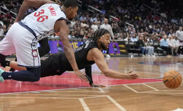 Brooklyn Nets forward Trendon Watford dives for the ball against Washington Wizards guard Marcus Smart (36) during the second half of an NBA basketball game, Monday, Feb. 24, 2025, in Washington. (AP Photo/Jess Rapfogel)