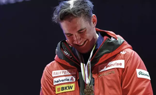 Switzerland's Franjo von Allmen, with his hair partially shaved off, wears the gold medal for a men's downhill race, at the Alpine Ski World Championships, in Saalbach-Hinterglemm, Austria, Sunday, Feb. 9, 2025. (AP Photo/Gabriele Facciotti)