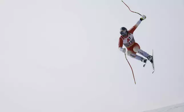 Switzerland's Franjo von Allmen is airborne during a men's downhill race, at the Alpine Ski World Championships, in Saalbach-Hinterglemm, Austria, Sunday, Feb. 9, 2025. (AP Photo/Gabriele Facciotti)