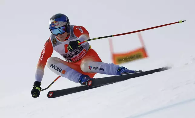 Switzerland's Marco Odermatt speeds down the course during a men's downhill race, at the Alpine Ski World Championships, in Saalbach-Hinterglemm, Austria, Sunday, Feb. 9, 2025. (AP Photo/Gabriele Facciotti)