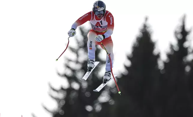 Switzerland's Franjo von Allmen is airborne during a men's downhill race, at the Alpine Ski World Championships, in Saalbach-Hinterglemm, Austria, Sunday, Feb. 9, 2025. (AP Photo/Marco Trovati)