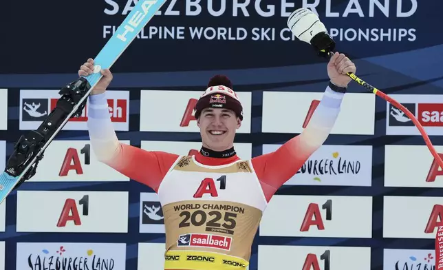 Switzerland's Franjo von Allmen celebrates winning a gold medal in a men's downhill race, at the Alpine Ski World Championships, in Saalbach-Hinterglemm, Austria, Sunday, Feb. 9, 2025. (AP Photo/Giovanni Auletta)