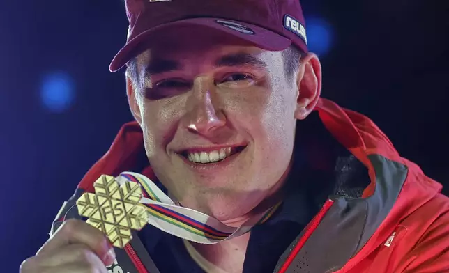 Switzerland's Franjo von Allmen shows his gold medal for a men's downhill race, at the Alpine Ski World Championships, in Saalbach-Hinterglemm, Austria, Sunday, Feb. 9, 2025. (AP Photo/Gabriele Facciotti)