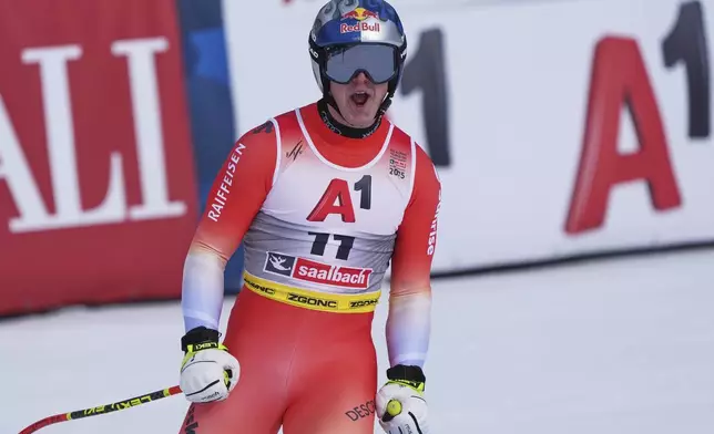 Switzerland's Franjo von Allmen celebrates at the finish area of a men's downhill race, at the Alpine Ski World Championships, in Saalbach-Hinterglemm, Austria, Sunday, Feb. 9, 2025. (AP Photo/Giovanni Auletta)