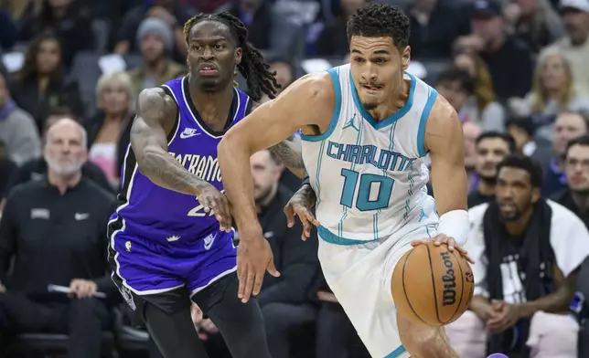 Charlotte Hornets guard Josh Green (10) drives past Sacramento Kings guard Keon Ellis, left, during the first half of an NBA basketball game in Sacramento, Calif., Monday, Feb. 24, 2025. (AP Photo/Randall Benton)
